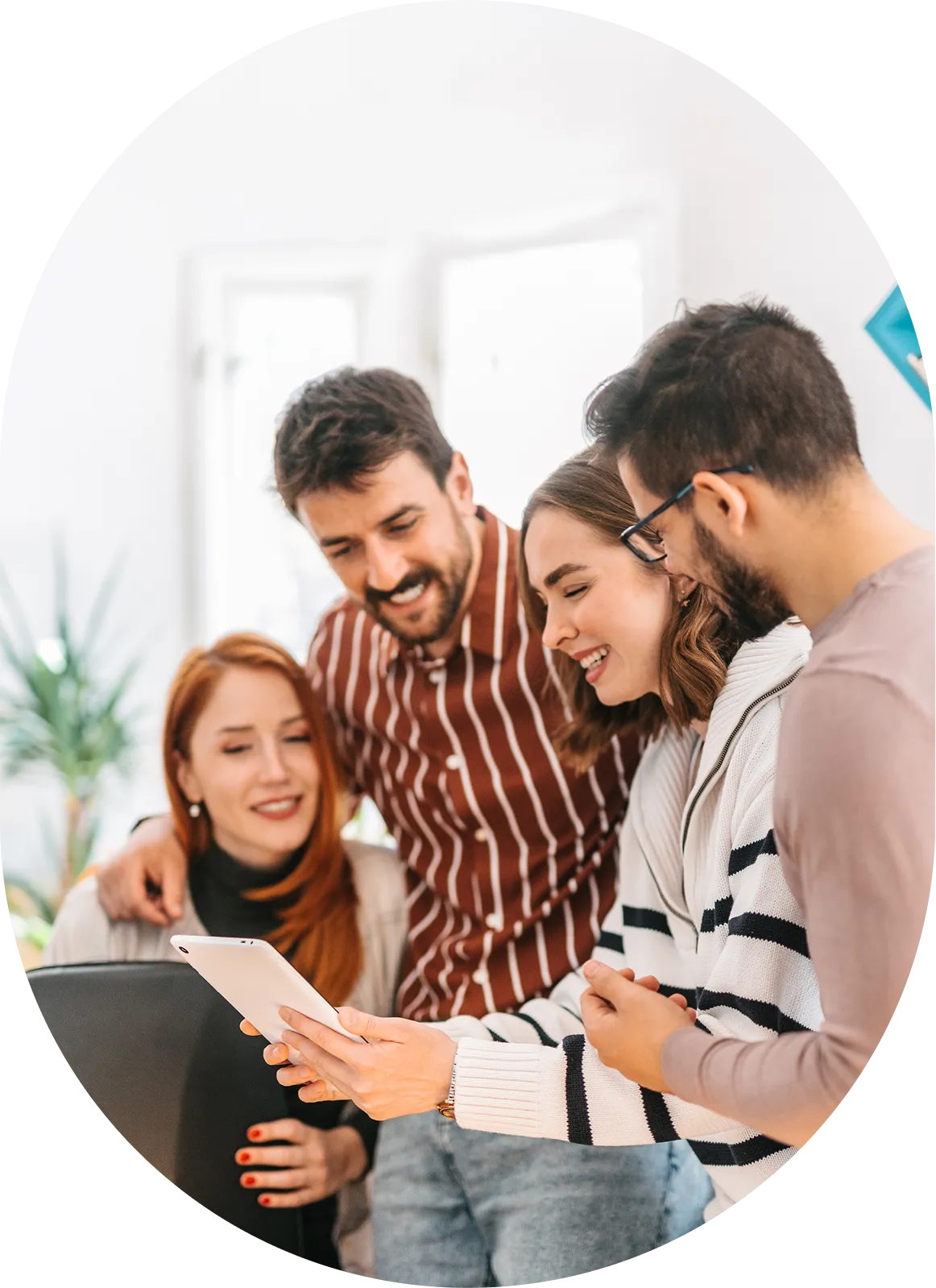 Group gathered around tablet, smiling and engaged.